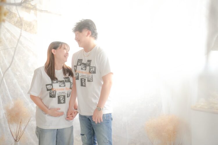 シャツとデニムでリンクコーデを楽しむ夫婦のナチュラルなマタニティショット