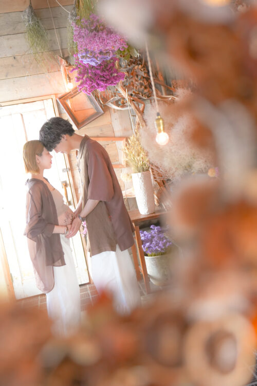 お腹にやさしく触れる夫婦のマタニティフォト
